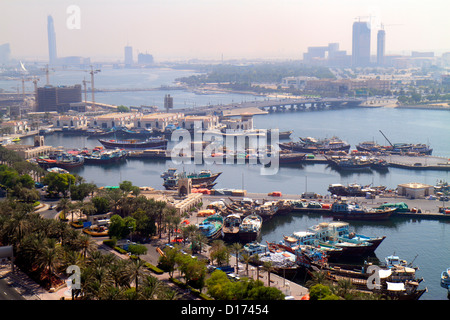 Dubai UAE,United Arab Emirates,Dubai Creek,port,cargo,boats,ships,dhow wharfs,Al Maktoum Bridge,distant D1 Tower,under new construction site building Stock Photo