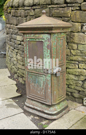 Old green iron cabinet box on Moss Lane in Bolton. Possibly part of an old telephone exchange or electrical mains installation. Stock Photo