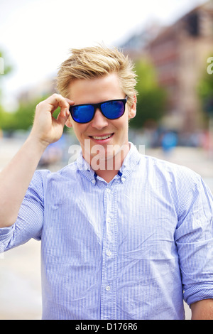 Portrait of a handsome and cool guy outdoors with his shades on Stock Photo