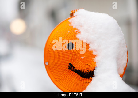 A smiley has been drawn on a constrcution site warning light, which is covered in snow, in Cologne, Germany, 07 December 2012. Photo: Rolf Vennenbernd Stock Photo