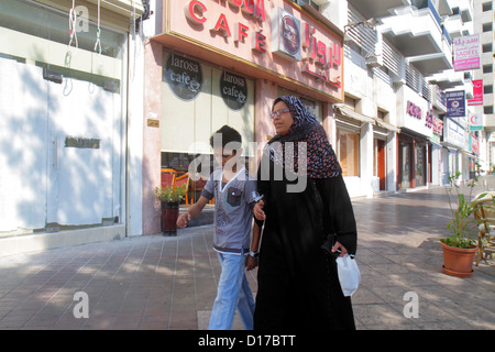 Dubai UAE,United Arab Emirates,Deira,Al Rigga Road,Muslim,Muslim ethnic woman female women,mother,parent,parents,thawb,robe,boy boys,male kid kids chi Stock Photo