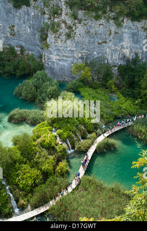 Tourists walking along wooden walkways in Plitvice Lakes National Park in Croatia. Stock Photo