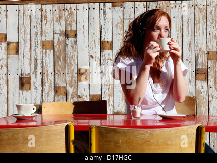 Woman in headphones drinking coffee Stock Photo