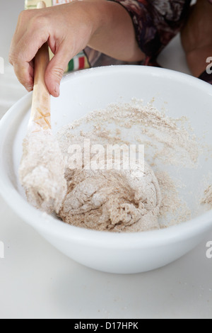 Close up of boy stirring dough in bowl Stock Photo