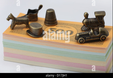 Monopoly money and metal playing traditional pieces. Stock Photo