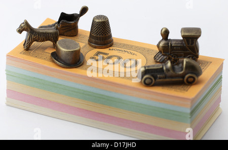 Monopoly money and metal playing traditional pieces. Stock Photo