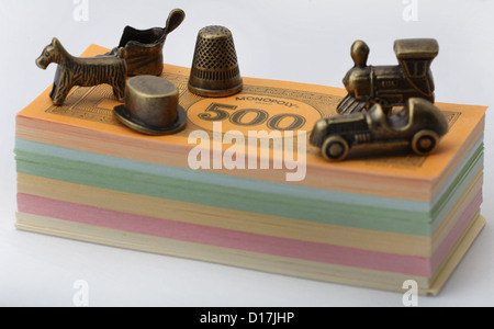 Monopoly money and metal playing traditional pieces. Stock Photo