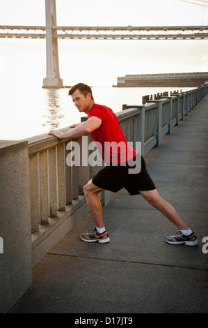 Man stretching on city street Stock Photo