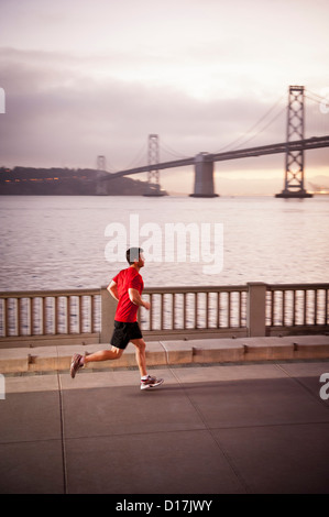 Man running on city street Stock Photo