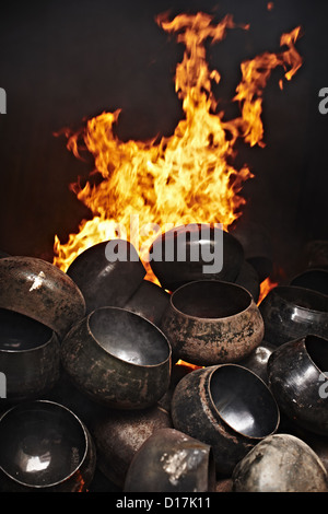 Metal pots piled by fire Stock Photo