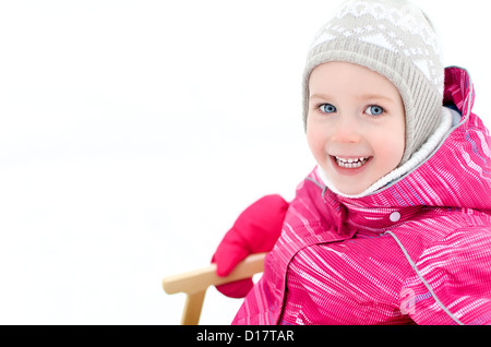 Portrait of cute little girl sitting in sled Stock Photo