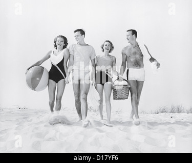Two couples walking on beach Stock Photo