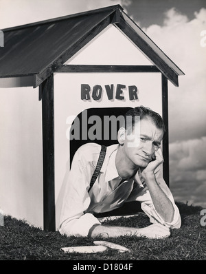 Man in the doghouse Stock Photo