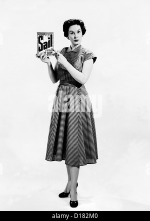 Housewife holding and pointing to detergent Stock Photo