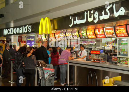 Dubai UAE,United Arab Emirates,Dubai International Airport,gate,Sheikh Rashid Terminal,travelers,English,Arabic,language,bilingual,McDonald's,burgers, Stock Photo