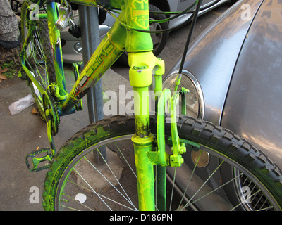 bike covered with bright green paint as anti theft system in street in rome italy Stock Photo