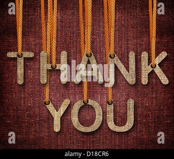 Thank you word hanging by rope as puppeteer on sackcloth background. Stock Photo