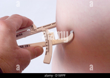 hHands using skin calipers to measure body fat Stock Photo