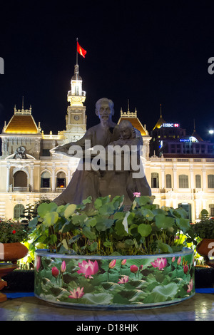 Statue of Ho Chi Minh cradling a child in front of City Hall (People's Committee Building) in Vietnam. Stock Photo