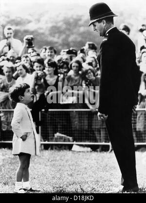 John F. Kennedy Jr. looks up at a British policeman during dedication ceremonies of a memorial to the late President Kennedy, Stock Photo