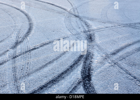Tyre tracks on icy frosty snow untreated road surfaces, Winter freeze weather road safety, UK. Stock Photo