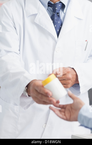 Pharmacist giving a box of pills to someone Stock Photo