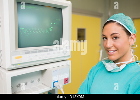 Smiling surgeon standing next to a monitor Stock Photo