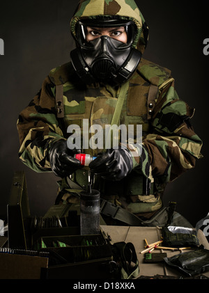 US Marine in MOPP gear inc gas mask uses M272 Chemical Agent Water Testing Kit ( lewisite, nerve agents, cyanide and mustard ) Stock Photo