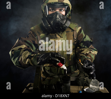 US Marine in MOPP gear inc gas mask uses M272 Chemical Agent Water Testing Kit ( lewisite, nerve agents, cyanide and mustard ) Stock Photo