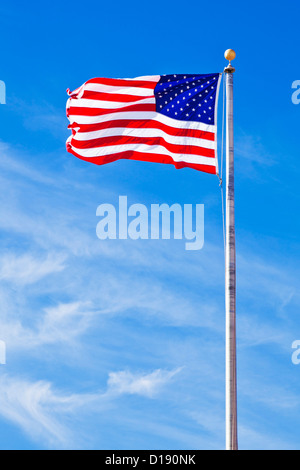 Stars and stripes flying against a blue sky USA US United States of America American flag Stock Photo