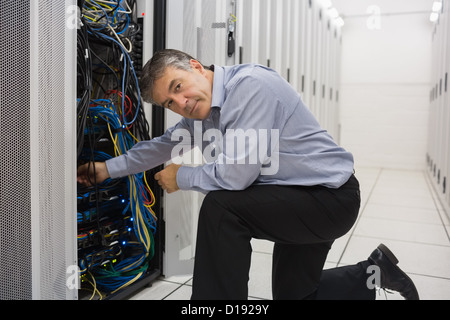 Technician kneeling and repairing a server Stock Photo