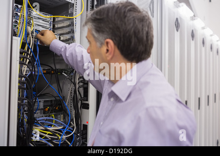 Technician putting up electric cables Stock Photo