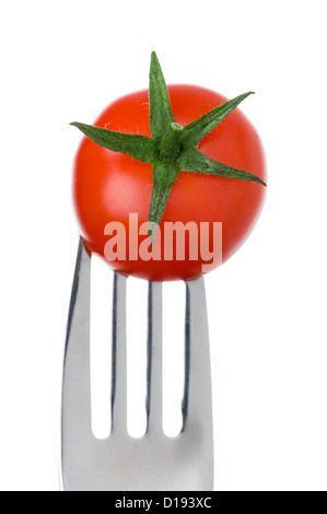cherry tomato on a fork against a white background Stock Photo