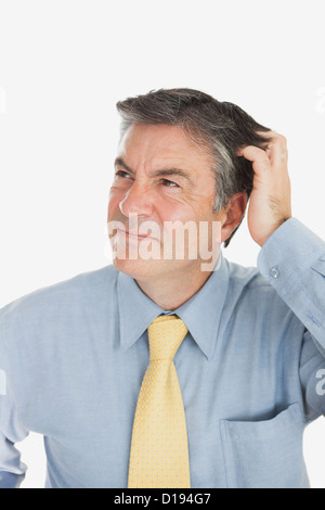 Confused businessman scratching head Stock Photo