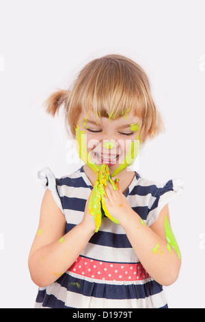 Small girl with paint on her cheek and nose isolated on grey Stock Photo