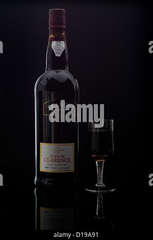 Blandy's Duke of Clarence rich Madeira wine shown bottled and in a small sherry like glass on a dark black background Stock Photo