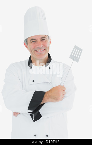 Man in chef uniform holding spatula Stock Photo