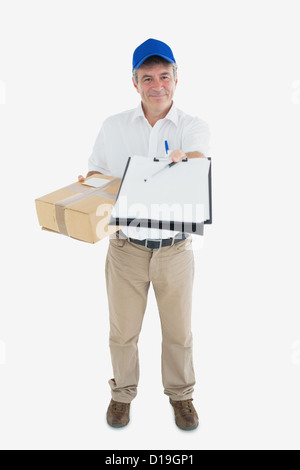 Happy courier man with package holding out clipboard Stock Photo