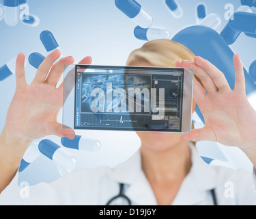 Cheerful blonde nurse holding a virtual screen Stock Photo