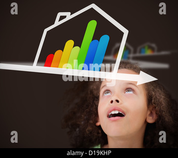 Surprised girl looking up at energy efficient house graphic Stock Photo