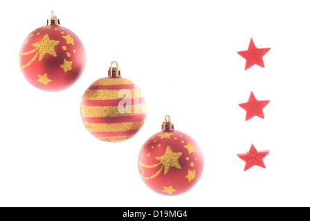 Three christmas balls and three red stars isolated on white. Strong glowing back light. Stock Photo