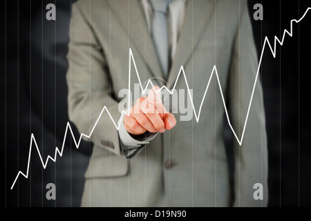 Businessman's finger activating curve on touch screen Stock Photo