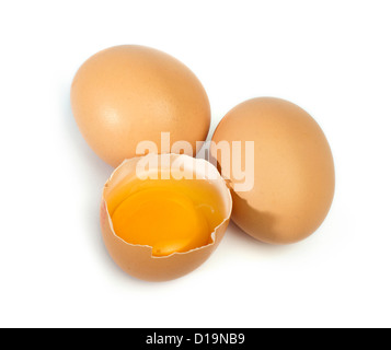 Tree whole eggs and another broken in half raw egg and yolk inside. Placed on white background. Stock Photo