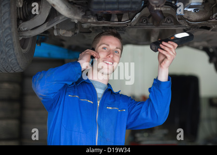 Car Mechanic using cell phone Stock Photo