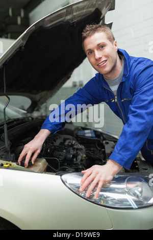 Mechanic closing lid of washer tank Stock Photo