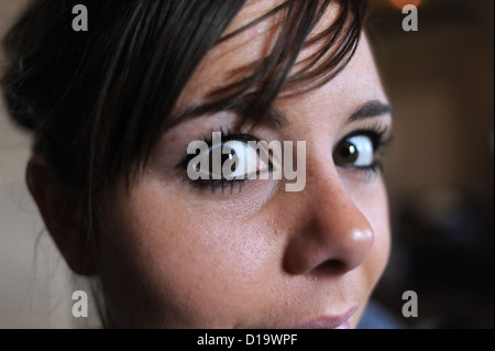 Young woman in her 20s with large eyes looking into camera Photograph taken by Simon Dack Stock Photo