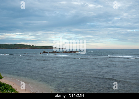Sri Lankan fishing boats sail towards Galle Fort at sunset Stock Photo