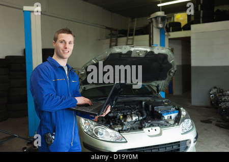 Repairman using laptop in workshop Stock Photo