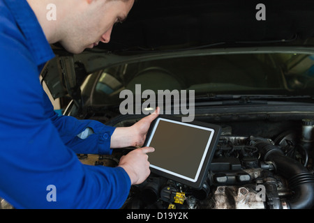 Mechanic using digital tablet Stock Photo