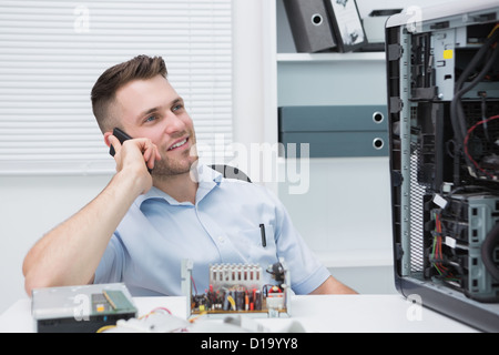 Smiling computer engineer on call by open cpu Stock Photo